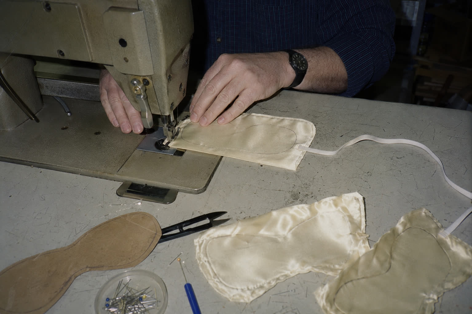 An early silk sleep mask being sewn in the family workshop